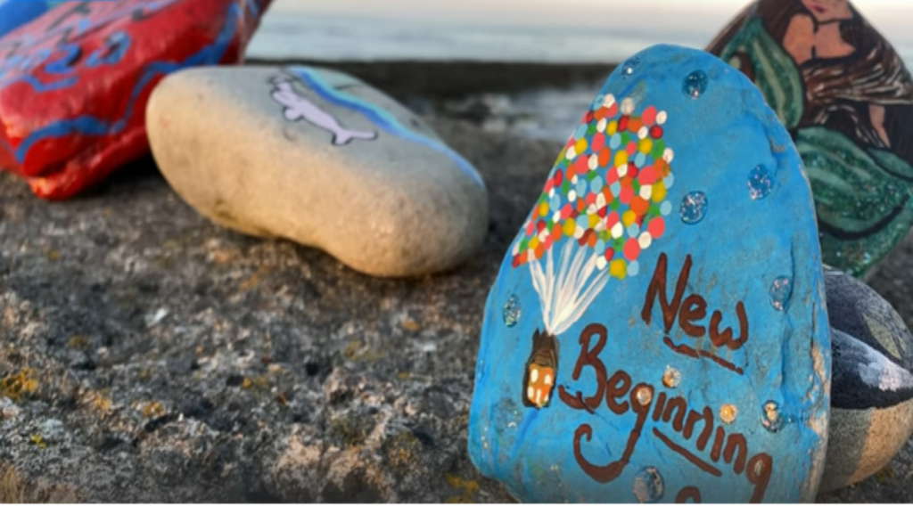 Pedras coloridas pintadas com mensagens de incentivo conseguiram criar uma comunidade.