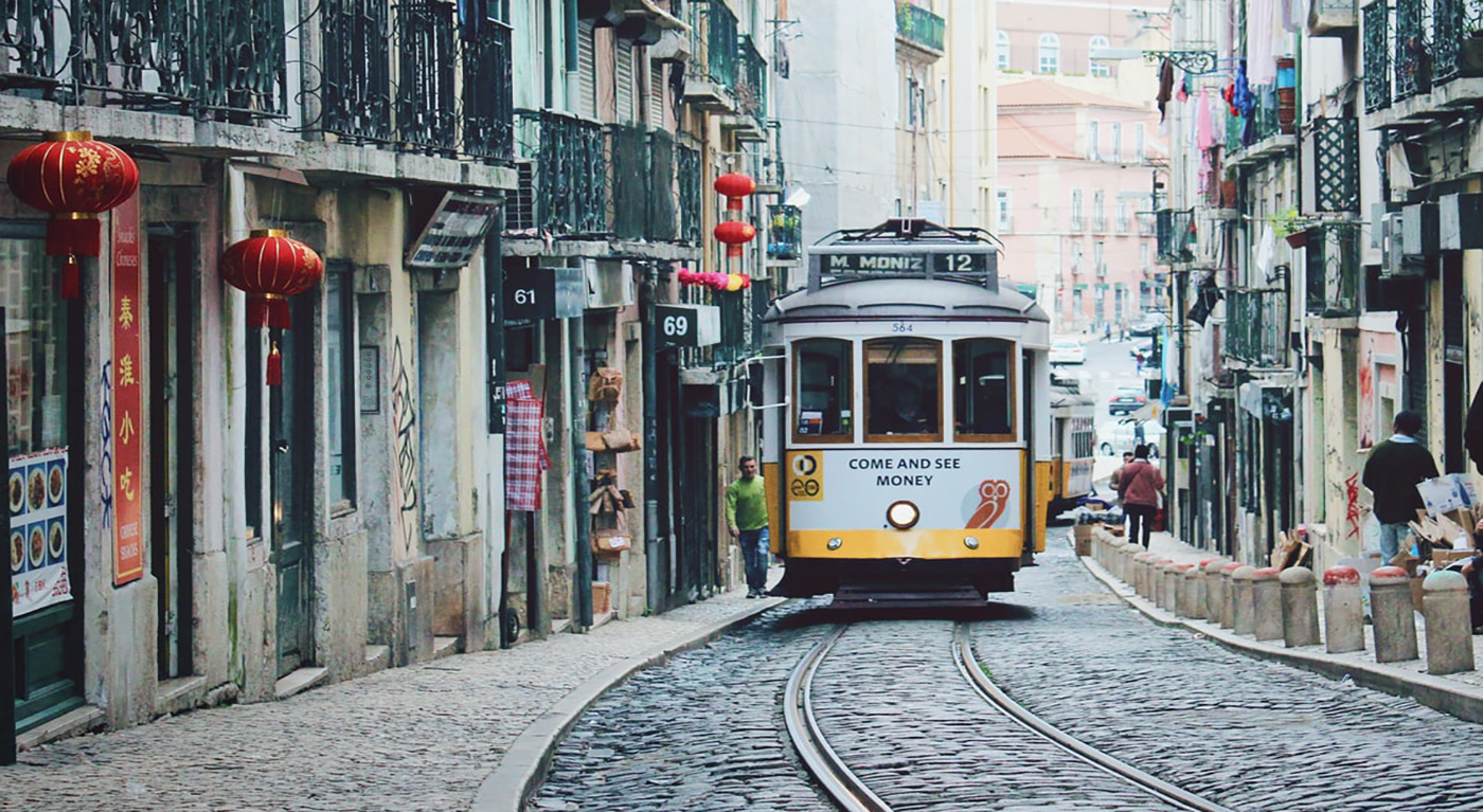 imagem empreender em Portugal: bonde amarelo em rua de paralelepípedos